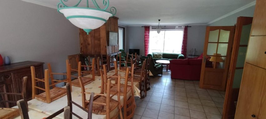 L'espace salle à manger. Salle à manger avec une table, chaises en bois et un salon à l'arrière-plan.