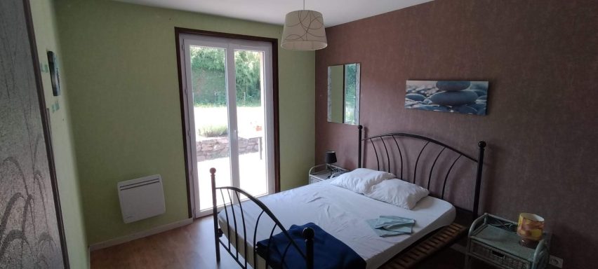 La chambre "zen" Chambre avec un lit, une fenêtre ouverte et des murs verts et bruns.